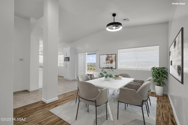 446 Soda Ln, Rio Rico, AZ 85648 - dining space with wood finished floors, arched walkways, and vaulted ceiling