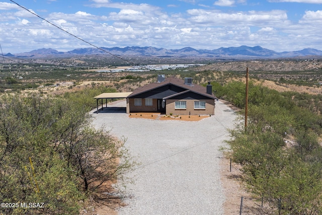 446 Soda Ln, Rio Rico, AZ 85648 - view of front of house featuring a mountain view, a chimney, brick siding, dirt driveway, and a detached carport