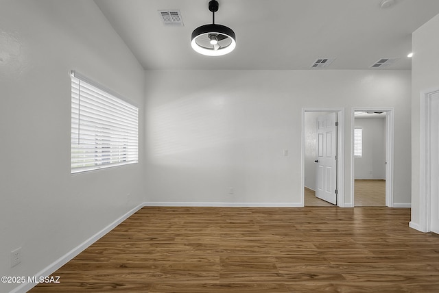 446 Soda Ln, Rio Rico, AZ 85648 - unfurnished room featuring wood finished floors, plenty of natural light, vaulted ceiling, and a smoke detector