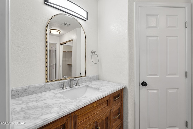 446 Soda Ln, Rio Rico, AZ 85648 - bathroom with a textured wall, vanity, and a closet