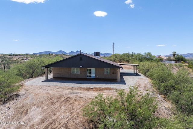 446 Soda Ln, Rio Rico, AZ 85648 - view of front of property with dirt driveway, brick siding, a carport, and a mountain view