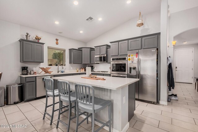 276 W Charles L Mckay St, Vail, AZ 85641 - kitchen featuring appliances with stainless steel finishes, lofted ceiling, a center island, arched walkways, and a breakfast bar area
