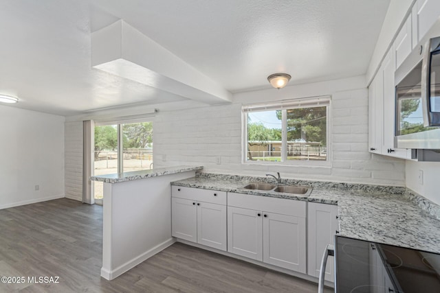 4041 E Dover Stra, Tucson, AZ 85706 - kitchen with stainless steel microwave, wood finished floors, range with electric cooktop, a peninsula, and healthy amount of natural light