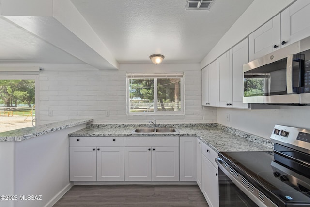 4041 E Dover Stra, Tucson, AZ 85706 - kitchen featuring appliances with stainless steel finishes, dark wood-style flooring, white cabinets, light stone counters, and a textured ceiling