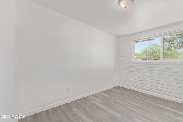 4041 E Dover Stra, Tucson, AZ 85706 - unfurnished room featuring light wood-style floors and brick wall