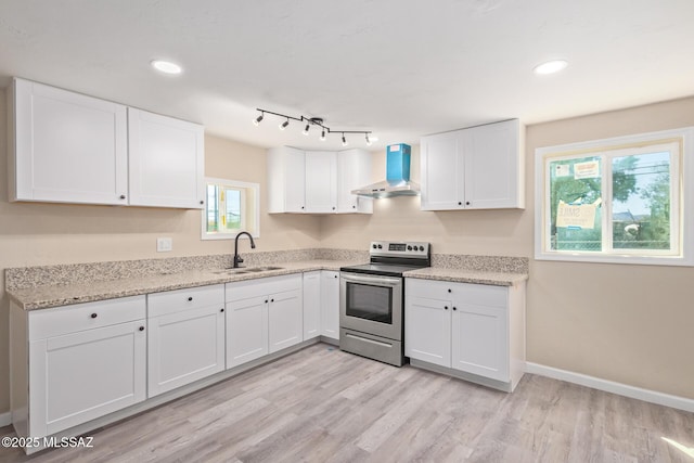2514 N Castro Ave, Tucson, AZ 85705 - kitchen with stainless steel electric range oven, wall chimney range hood, white cabinets, light wood finished floors, and light stone counters