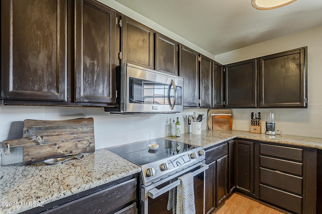 6490 N Tierra De Las Catalinas Unit 94, Tucson, AZ 85718 - kitchen featuring appliances with stainless steel finishes, backsplash, dark brown cabinetry, and light stone counters