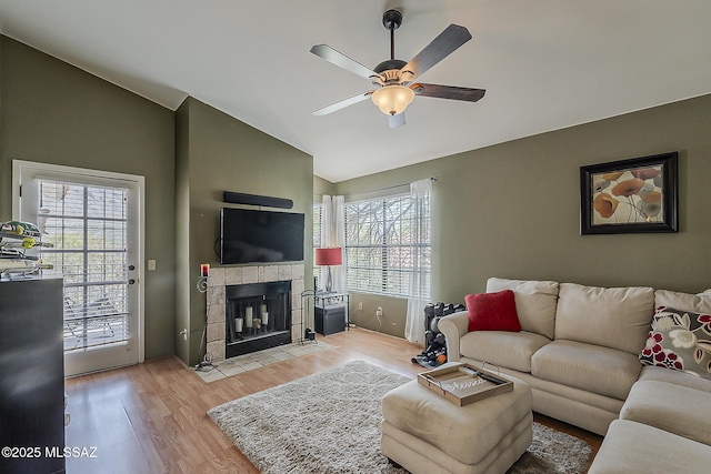 6490 N Tierra De Las Catalinas Unit 94, Tucson, AZ 85718 - living room featuring lofted ceiling, ceiling fan, light wood-type flooring, and a tiled fireplace