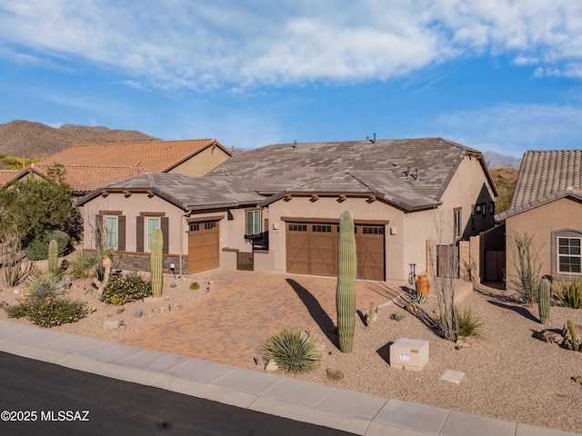 14326 Whitehorn Pl, Marana, AZ 85658 - view of front of house featuring a garage, stucco siding, decorative driveway, and a mountain view