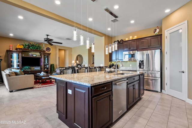 14326 Whitehorn Pl, Marana, AZ 85658 - kitchen with appliances with stainless steel finishes, dark brown cabinets, a ceiling fan, hanging light fixtures, and light tile patterned floors
