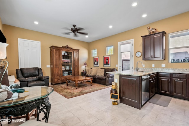14326 Whitehorn Pl, Marana, AZ 85658 - kitchen featuring open floor plan, stainless steel dishwasher, dark brown cabinets, ceiling fan, and light stone countertops