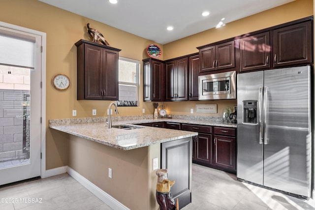 14326 Whitehorn Pl, Marana, AZ 85658 - kitchen featuring appliances with stainless steel finishes, plenty of natural light, dark brown cabinetry, light stone counters, and recessed lighting