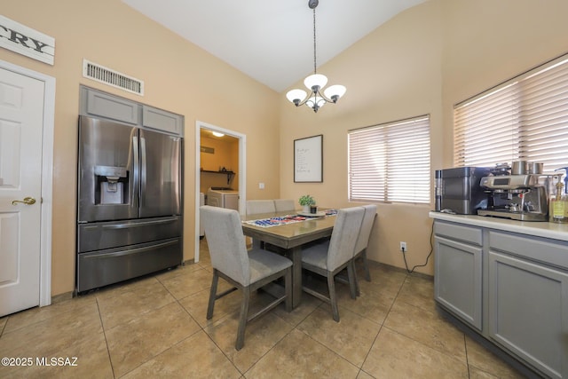 6976 Somerton Dr, Tucson, AZ 85743 - dining space with washer and dryer, a chandelier, light tile patterned floors, and high vaulted ceiling