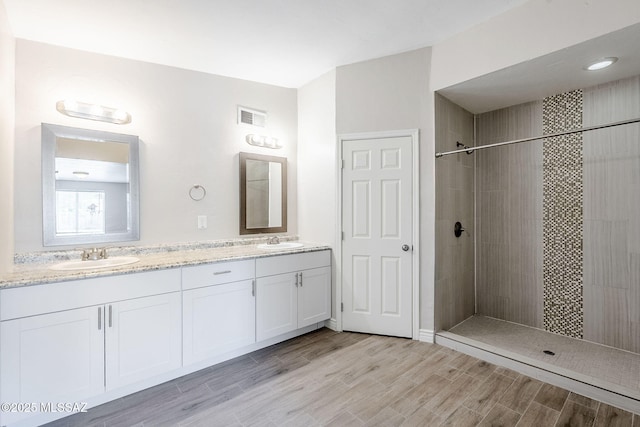 18 E Mac Iver Pl, Tucson, AZ 85705 - full bathroom with double vanity, tiled shower, and wood finished floors