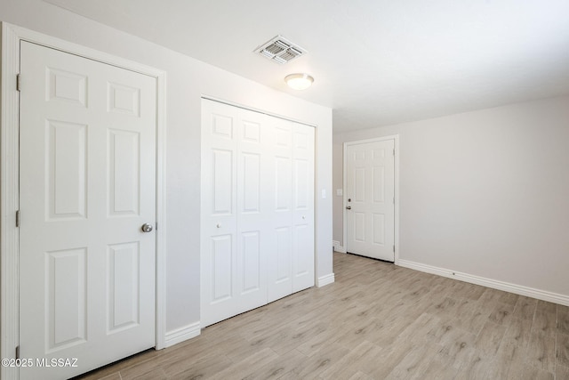 18 E Mac Iver Pl, Tucson, AZ 85705 - unfurnished bedroom featuring light wood finished floors and a closet