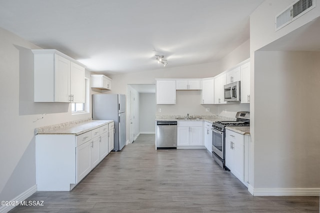 18 E Mac Iver Pl, Tucson, AZ 85705 - kitchen featuring stainless steel appliances, light wood-style flooring, light countertops, and white cabinets