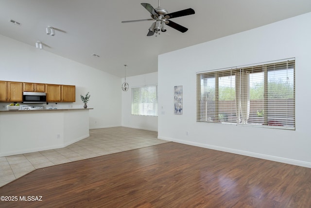 9438 N Weather Hill Dr, Tucson, AZ 85743 - unfurnished living room with a ceiling fan, high vaulted ceiling, and light wood-style flooring