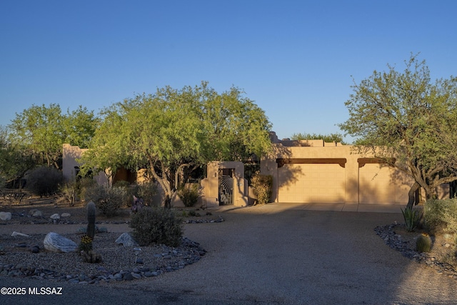10380 E Rancho Del Este Dr, Tucson, AZ 85749 - southwest-style home with stucco siding, an attached garage, and driveway