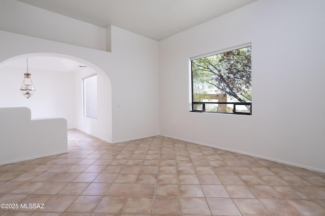 10380 E Rancho Del Este Dr, Tucson, AZ 85749 - spare room featuring arched walkways and light tile patterned floors