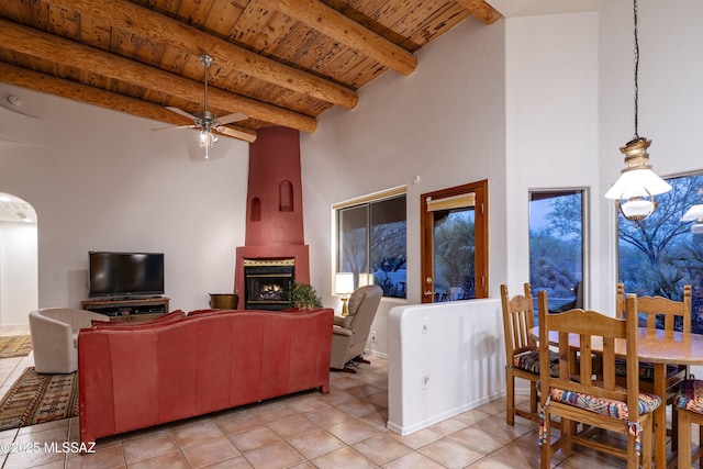 10380 E Rancho Del Este Dr, Tucson, AZ 85749 - living room featuring a wood ceiling with exposed beams, light tile patterned flooring, ceiling fan, and a towering ceiling