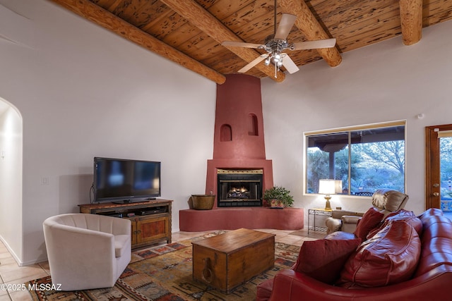 10380 E Rancho Del Este Dr, Tucson, AZ 85749 - living area with a wooden ceiling with exposed beams, tile patterned floors, ceiling fan, a large fireplace, and arched walkways