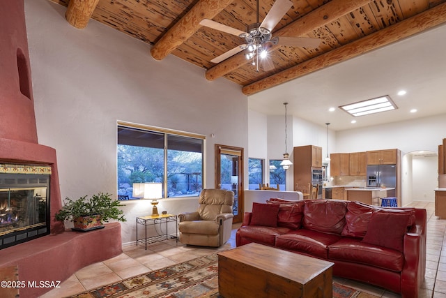 10380 E Rancho Del Este Dr, Tucson, AZ 85749 - living room with a wood ceiling with exposed beams, light tile patterned flooring, a towering ceiling, a ceiling fan, and arched walkways