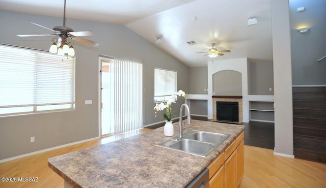 5553 W Carriage Dr, Tucson, AZ 85742 - kitchen with ceiling fan, light wood-type flooring, lofted ceiling, a fireplace, and an island with sink