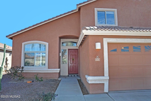 5553 W Carriage Dr, Tucson, AZ 85742 - mediterranean / spanish-style home with stucco siding, a tiled roof, and an attached garage