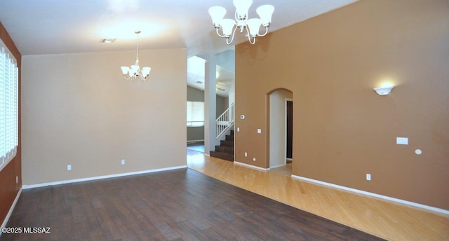 5553 W Carriage Dr, Tucson, AZ 85742 - unfurnished room with a chandelier, arched walkways, wood finished floors, stairs, and vaulted ceiling
