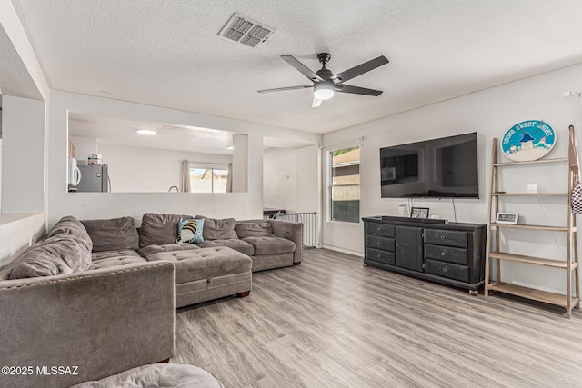 6293 S Sun View Way, Tucson, AZ 85706 - living room featuring ceiling fan, wood finished floors, a textured ceiling, and radiator heating unit