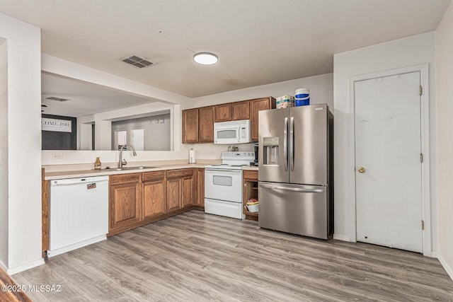 6293 S Sun View Way, Tucson, AZ 85706 - kitchen with white appliances, light wood-type flooring, light countertops, and brown cabinetry