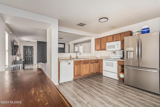 6293 S Sun View Way, Tucson, AZ 85706 - kitchen featuring white appliances, light wood-style flooring, light countertops, and brown cabinets