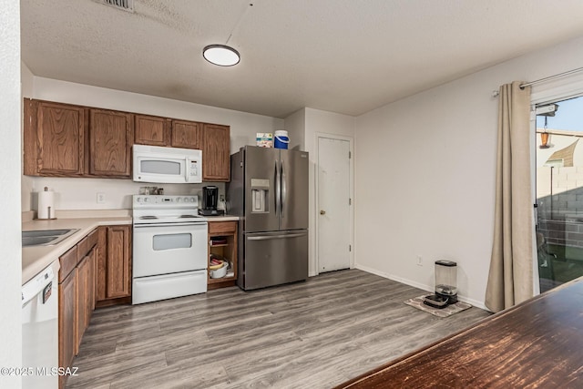 6293 S Sun View Way, Tucson, AZ 85706 - kitchen featuring white appliances, light wood-style flooring, brown cabinets, and light countertops
