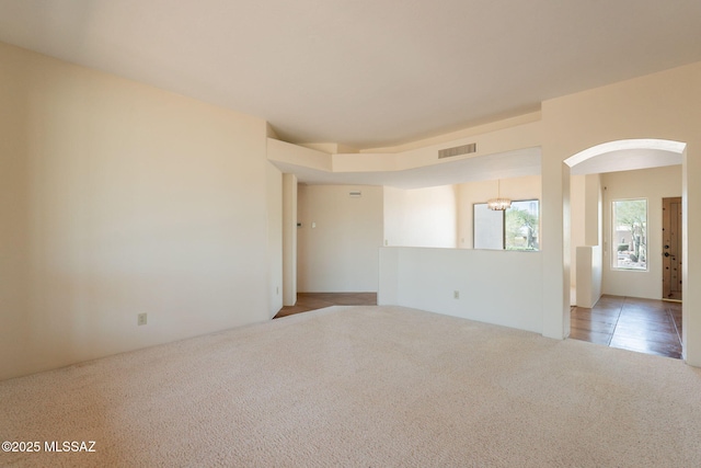 3655 N Harrison Rd, Tucson, AZ 85749 - carpeted empty room with arched walkways and a chandelier
