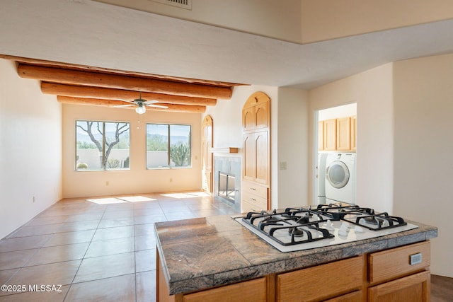 3655 N Harrison Rd, Tucson, AZ 85749 - kitchen with white gas cooktop, washer and dryer, light tile patterned floors, a ceiling fan, and tile counters