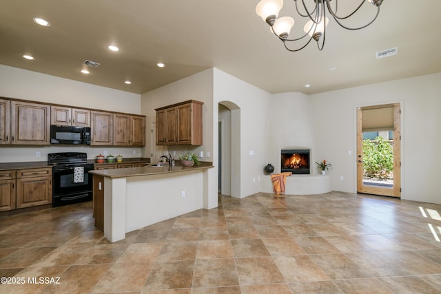 341 E Calderwood Rd, Tucson, AZ 85704 - kitchen featuring black appliances, open floor plan, arched walkways, a fireplace, and recessed lighting
