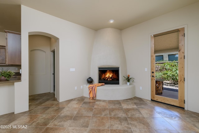 341 E Calderwood Rd, Tucson, AZ 85704 - unfurnished living room featuring a fireplace and arched walkways