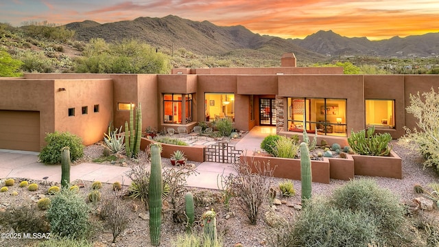 5254 W Saguaro Cliffs Dr, Tucson, AZ 85745 - view of front of property with a mountain view, a fenced front yard, a chimney, stucco siding, and a garage