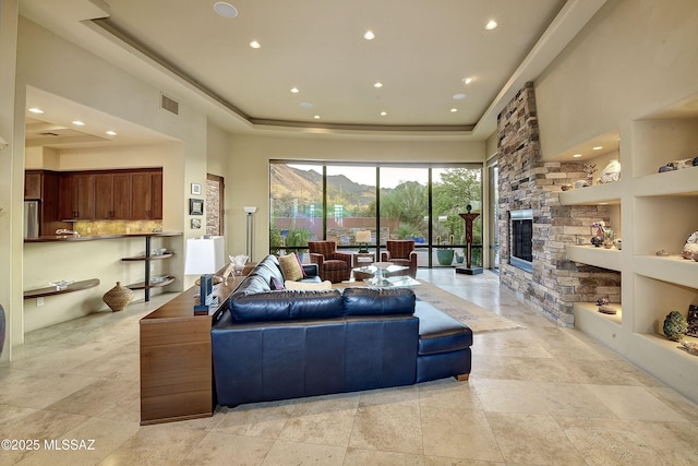 5254 W Saguaro Cliffs Dr, Tucson, AZ 85745 - living area with a tray ceiling, recessed lighting, and a stone fireplace