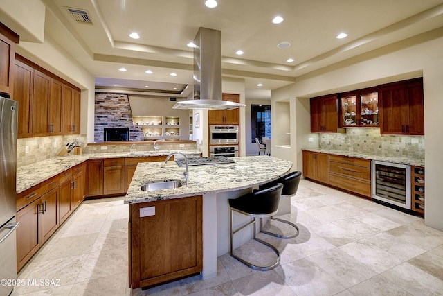 5254 W Saguaro Cliffs Dr, Tucson, AZ 85745 - kitchen with beverage cooler, a tray ceiling, tasteful backsplash, island range hood, and light stone counters