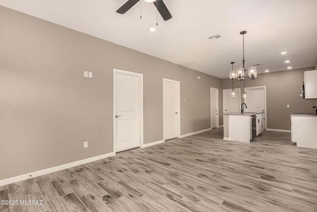 3710 S Bellingham Pl, Tucson, AZ 85730 - unfurnished living room with ceiling fan, light wood finished floors, recessed lighting, and a chandelier