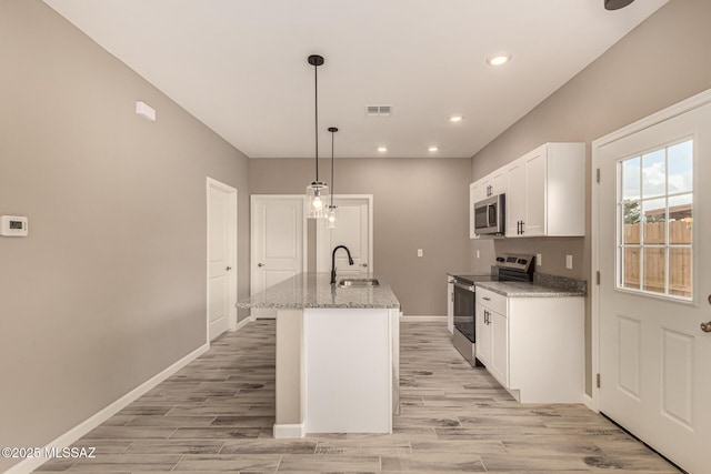 3710 S Bellingham Pl, Tucson, AZ 85730 - kitchen with appliances with stainless steel finishes, white cabinets, light stone counters, recessed lighting, and light wood finished floors