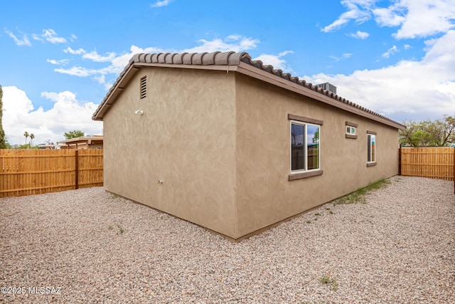 3710 S Bellingham Pl, Tucson, AZ 85730 - view of side of home featuring a fenced backyard, stucco siding, and a tiled roof