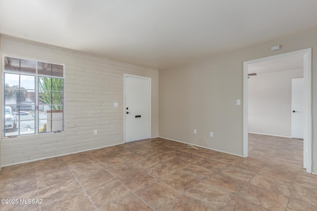 235 S Paseo Quinta Apt B, Green Valley, AZ 85614 - spare room featuring brick wall and stone finish floors