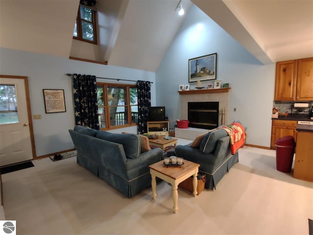 living room with light carpet, high vaulted ceiling, and a tile fireplace