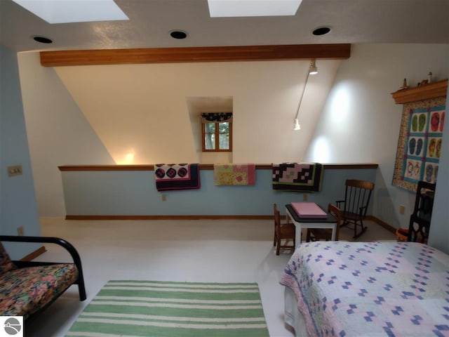 carpeted bedroom featuring track lighting, beam ceiling, and a skylight