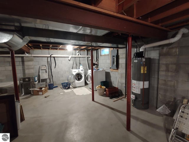 basement featuring electric panel, washing machine and dryer, and water heater