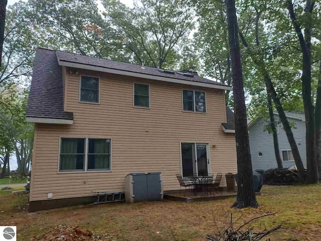 rear view of property featuring a lawn