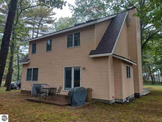 rear view of property featuring a yard and a patio area