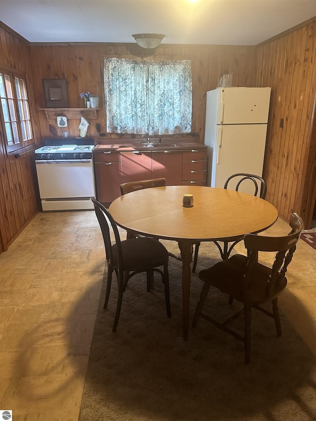 dining room with wood walls and sink